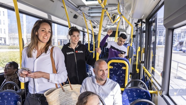 Reizigers in een bus van Arriva Mensen in een Arriva bus lachen en praten met elkaar