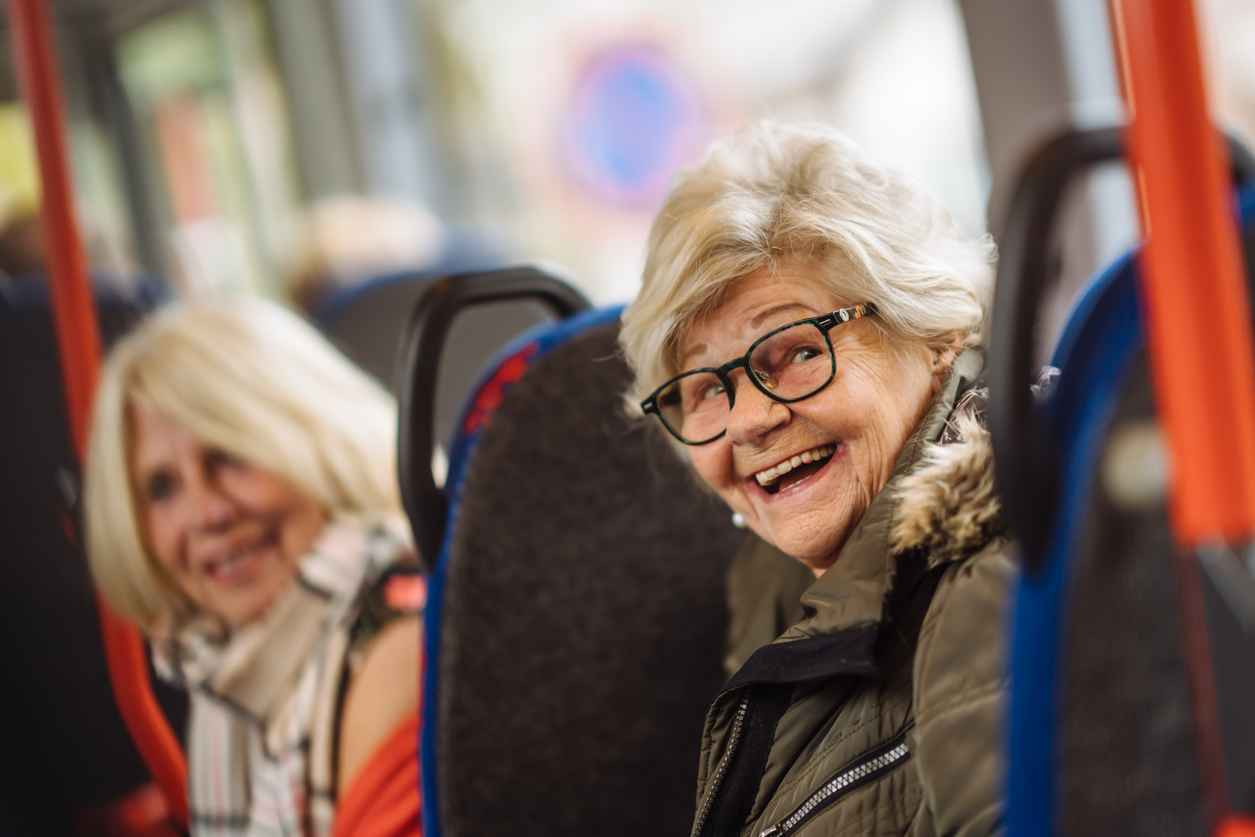 Twee wmo reizigers lachen in de bus