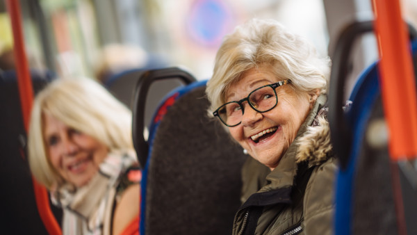 Twee wmo reizigers lachen in de bus Twee wmo reizigers lachen in de bus
